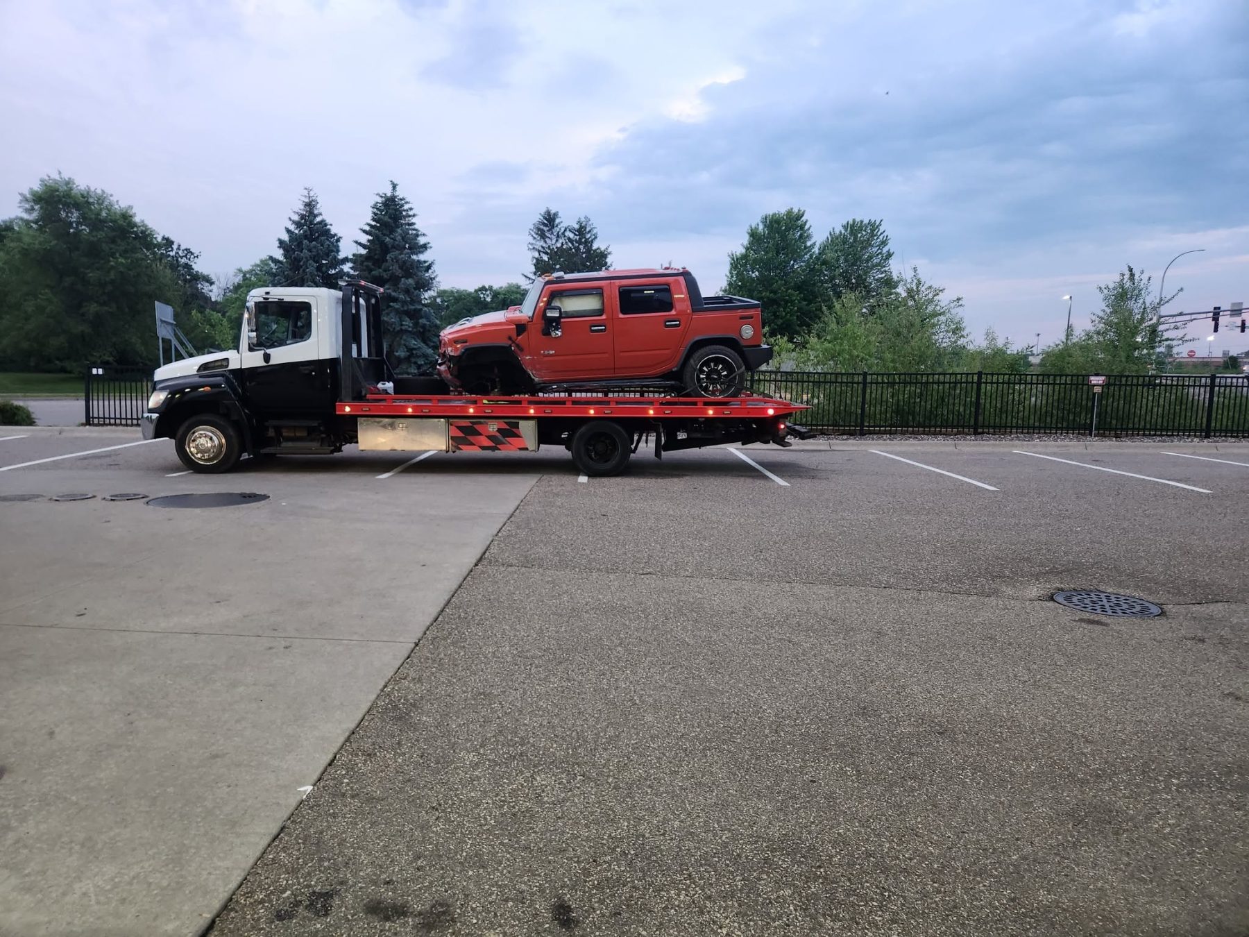 K & M Towing flatbed carrying a red Hummer H2